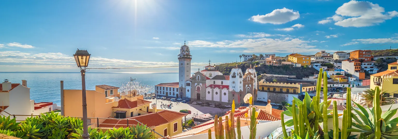 Uitzicht op een stadje op Tenerife met in de achtergrond een blauwe Atlantische Oceaan.